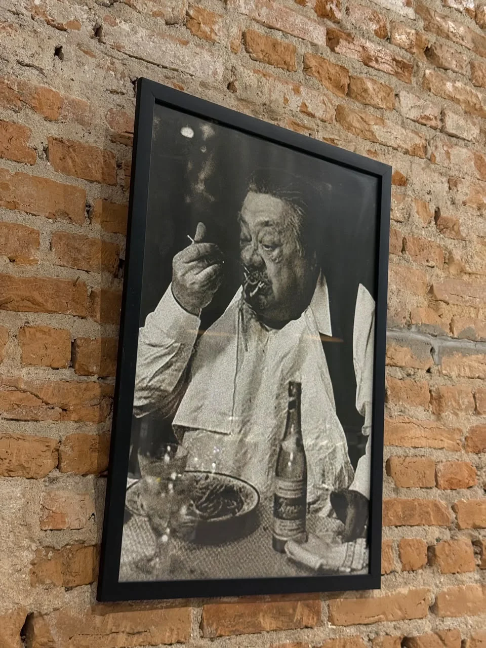 Fotografia emoldurada na parede de tijolos da Vila109