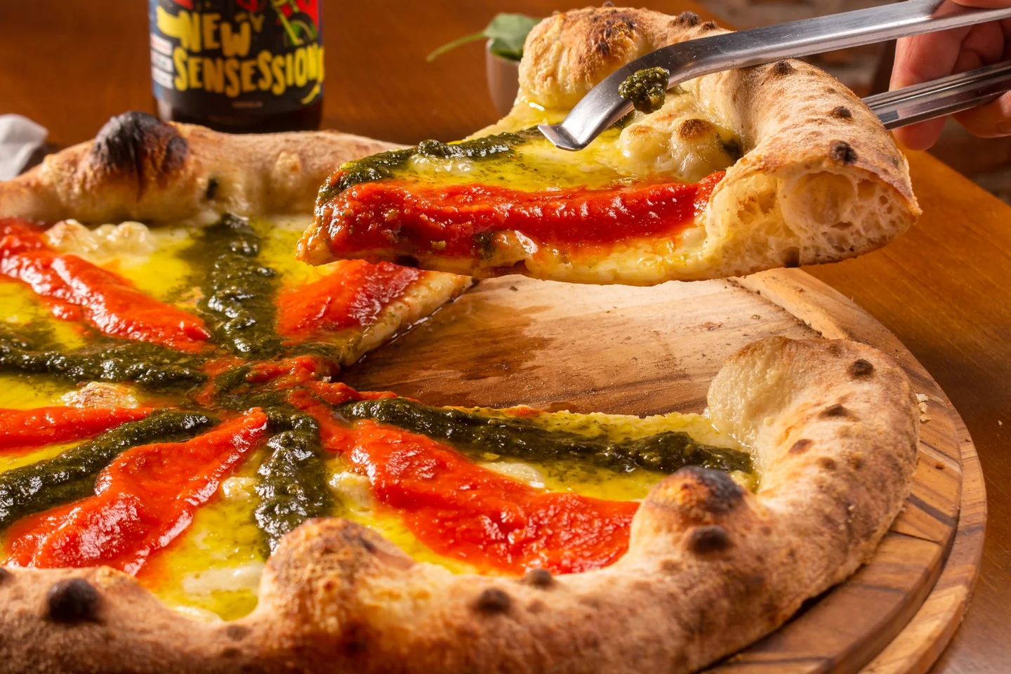 Fatia de uma pizza da Vila109 sendo servida